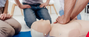 cropped view of man performing chest compression on dummy during cpr training class