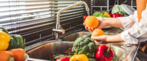 Hand of maid washing tomato fresh vegetables preparation