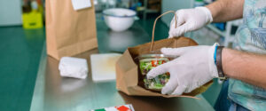 Unrecognizable cook packing a takeaway order