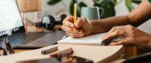 African american young woman using laptop and taking notes